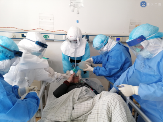 李立斌主任（中）戴著正壓頭套，為新冠肺炎危重癥病人